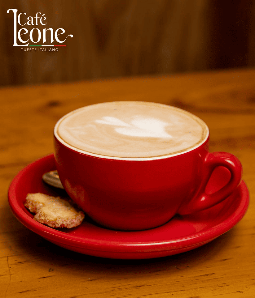 Cappuccino de Leone servido en taza roja con arte latte